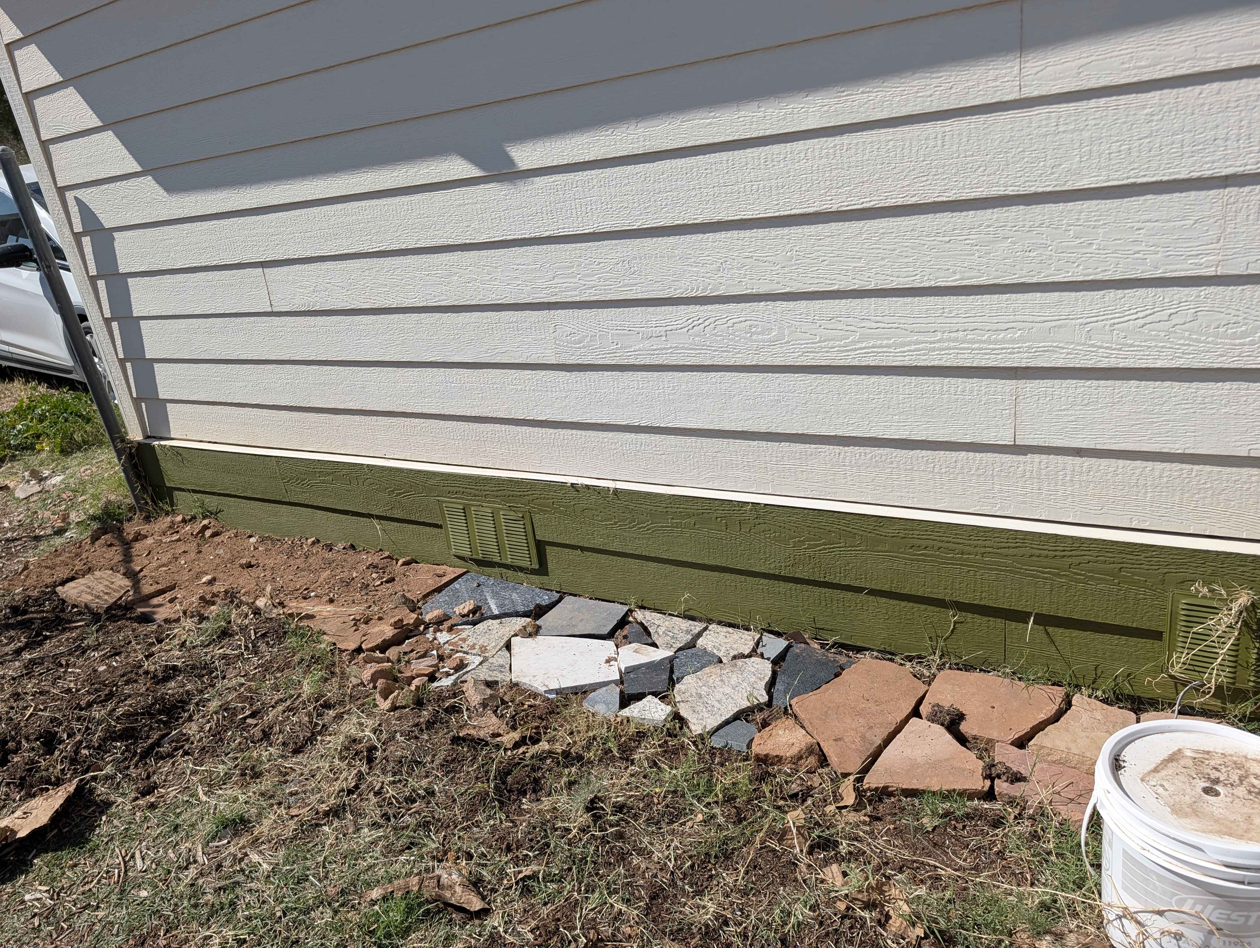 slate stone and sand against wall of house.